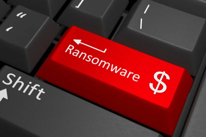 Tecla roja de teclado etiquetada Ransomware con un signo de dólar. Las llaves alrededor son grises. Representa amenazas cibernéticas e impacto financiero.